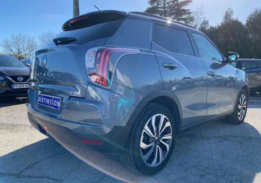 Vue 3/4 arrière droite d'un SsangYong Tivoli gris foncé 2021 avec jantes alliage et vitres teintées.