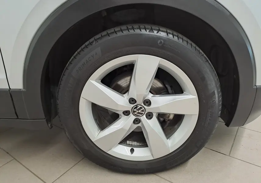 Gros plan sur la roue avant gauche du Volkswagen T-cross 2022 en peinture métallisée Reflet d'argent.