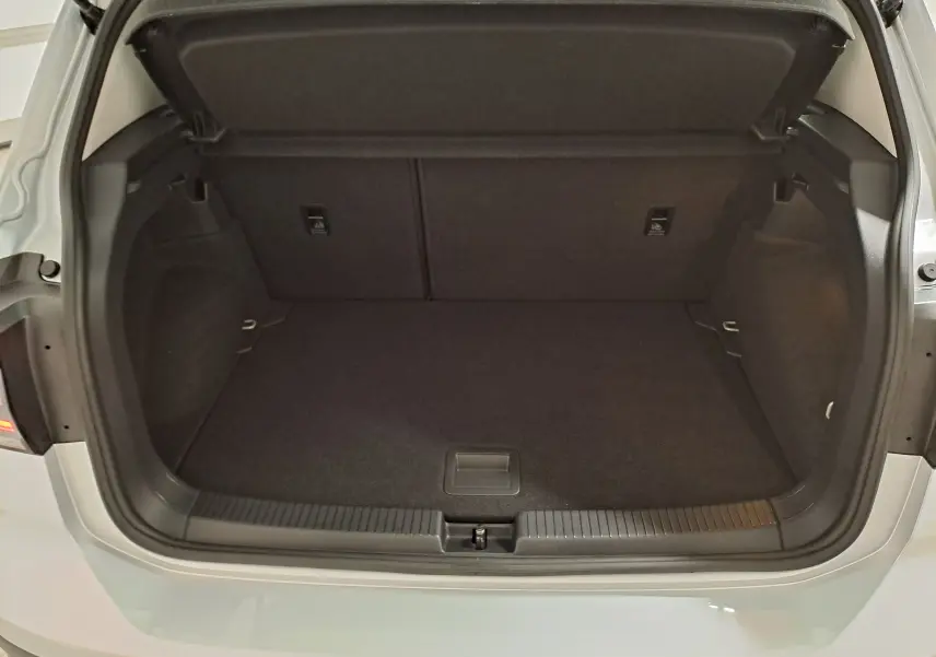 Coffre ouvert vu de face d'un Volkswagen T-Cross 2022 argenté, montrant un espace de chargement propre et vide.