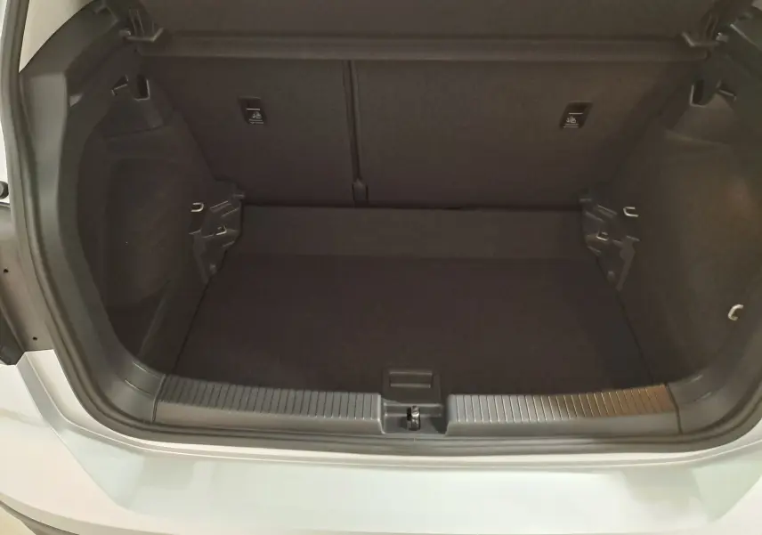 Coffre ouvert vu de l'arrière d'un Volkswagen T-Cross 2022 couleur reflet d'argent, montrant l'espace de chargement vide.