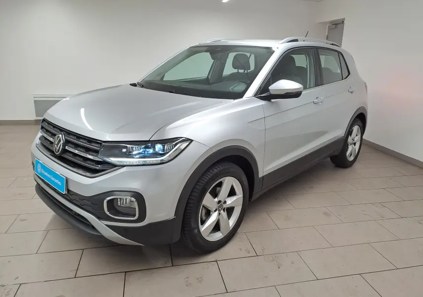 Volkswagen T-Cross 1.0 TSI 110 DSG7 Style en reflet d'argent, vue 3/4 avant avec phares LED allumés.