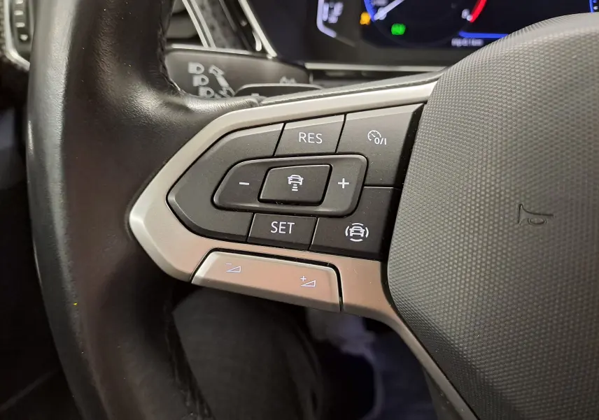 Gros plan sur les commandes au volant côté gauche du Volkswagen T-Cross 2022, finition Style, avec boutons de régulateur de vitesse.