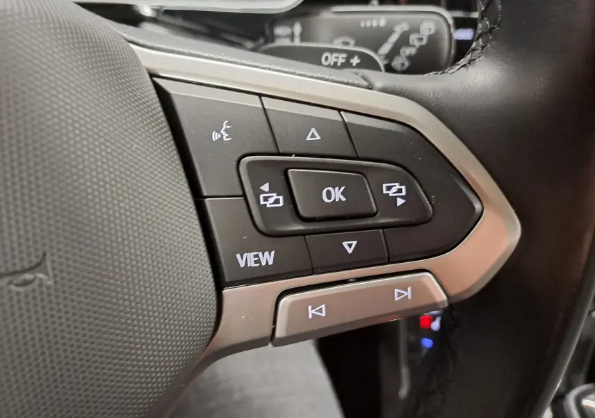 Gros plan sur les commandes multifonctions à droite du volant noir du Volkswagen T-Cross 2022 finition Style.