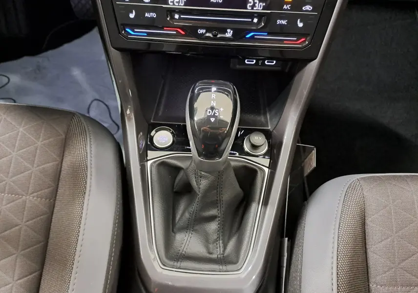 Gros plan sur la console centrale du Volkswagen T-Cross 2022, levier de vitesse automatique et commandes climatisation visibles.