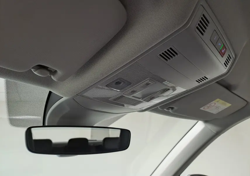 Vue intérieure du plafond avant du Volkswagen T-Cross 2022, montrant les commandes d’éclairage et le rétroviseur central.