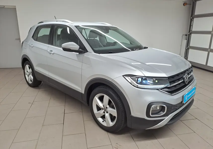 Volkswagen T-Cross 2022 argent métallisé en 3/4 avant droit avec phares LED allumés en intérieur.