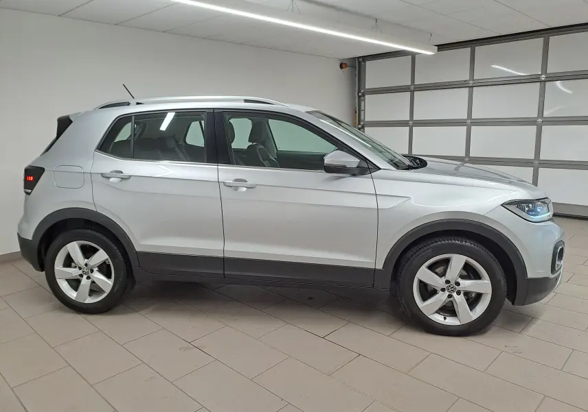 Volkswagen T-Cross 1.0 TSI 110 DSG7 Style en reflet d'argent, vue profil côté gauche dans un garage intérieur.
