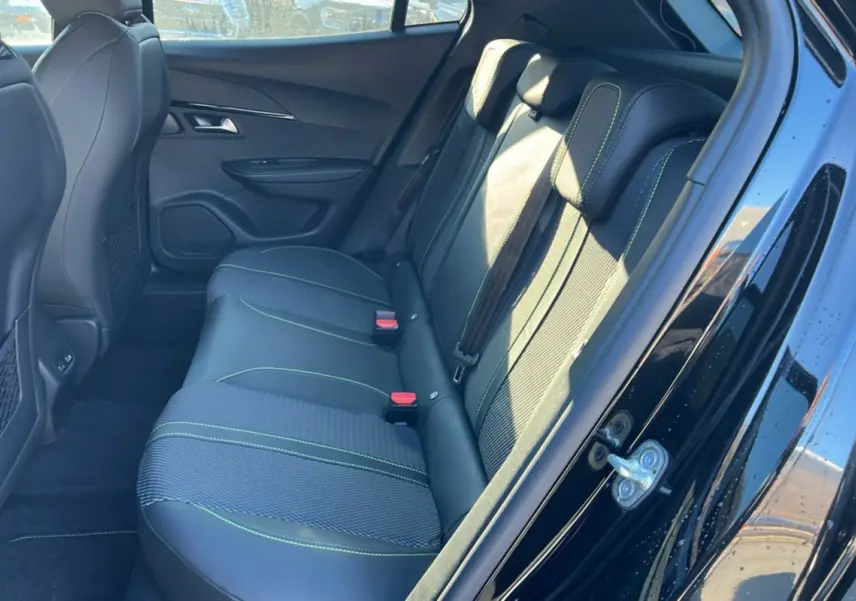Vue intérieure côté gauche sur la banquette arrière en cuir tissu noir avec surpiqûres vertes du Peugeot 2008 Hybrid 145 GT Vision 2025.