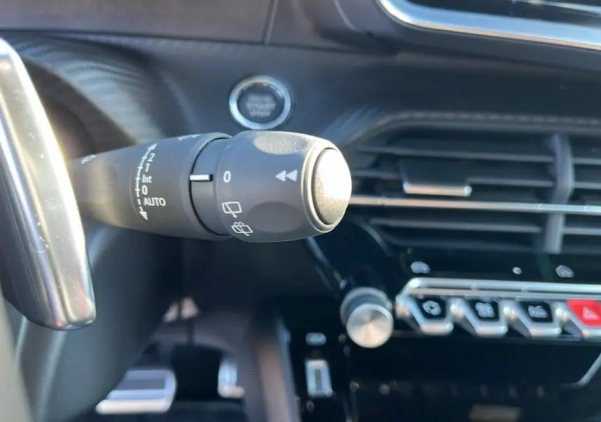 Gros plan sur la commande d’essuie-glace du tableau de bord noir du Peugeot 2008 Hybrid 145 GT Vision 2025.