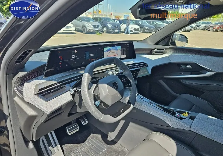 Vue intérieure côté conducteur du Peugeot 5008 Hybrid gris titane, avec tableau de bord numérique et volant multifonction.