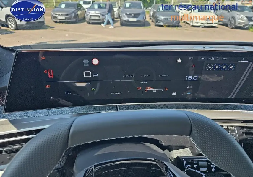 Vue intérieure du tableau de bord numérique et volant cuir perforé d'une Peugeot 5008 gris titane, version Hybrid 145 GT.