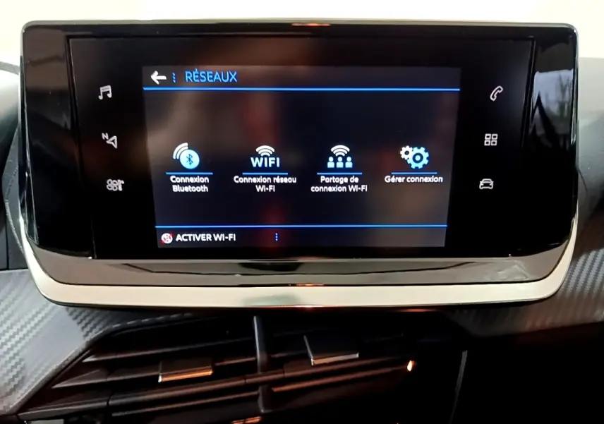 Écran tactile central de la Peugeot 208 blanc, affichant les options de connexion Bluetooth et Wi-Fi, vue de face.