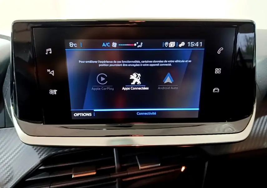 Écran tactile central du tableau de bord du Peugeot 208 blanc, affichant les options Apple CarPlay et Android Auto.