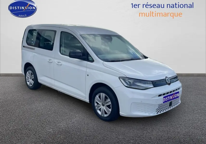 Volkswagen Caddy blanc vue 3/4 avant droit sur fond neutre avec calandre moderne et phares effilés.