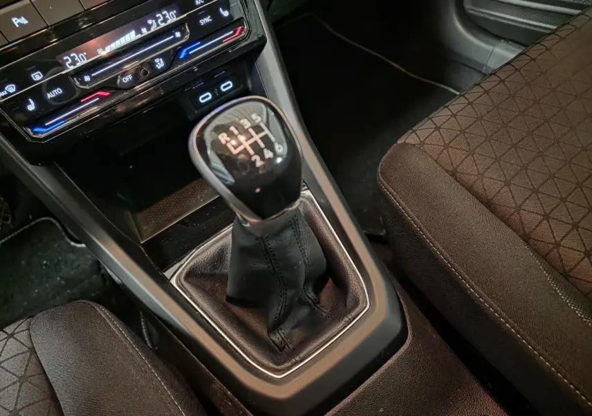 Gros plan sur le levier de vitesses manuel noir et la console centrale du Volkswagen T-Cross 1.0 TSI 110 Active.