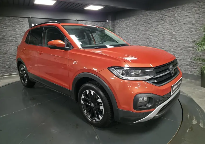 Volkswagen T-Cross orange Energy en 3/4 avant droit, jantes alliage noires et calandre noire avec liseré chromé.