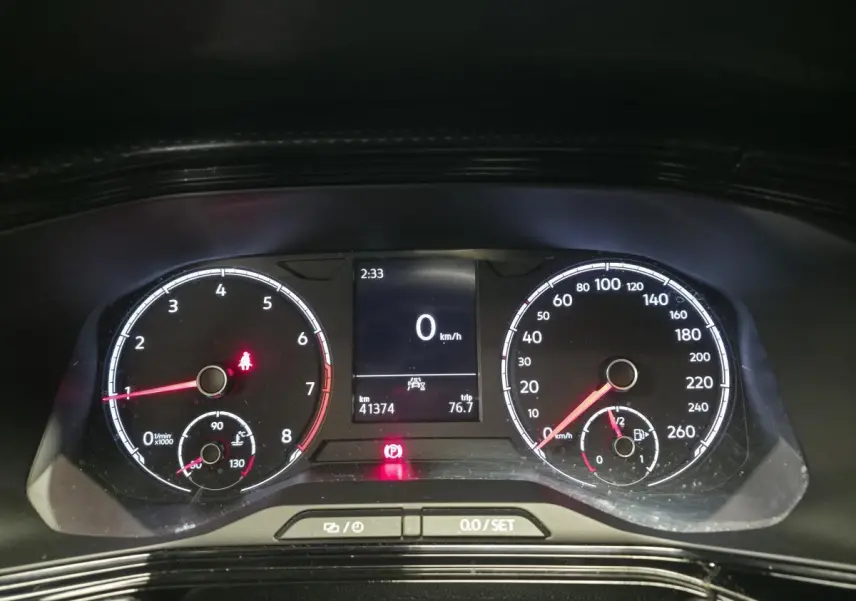 Tableau de bord numérique du Volkswagen T-Cross 1.0 TSI 110 Active, affichant vitesse à 0 km/h et compteurs analogiques.
