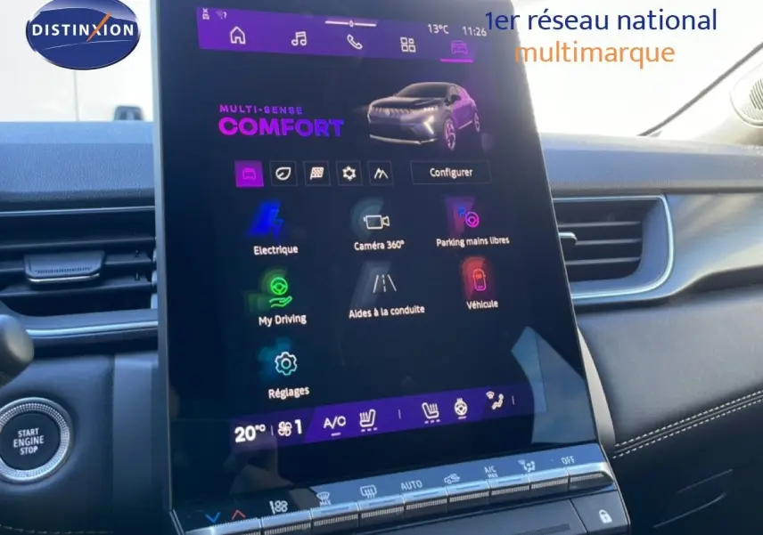 Vue intérieure centrée sur l'écran tactile vertical du tableau de bord du Renault Symbioz bleu, avec commandes climatisation visibles.