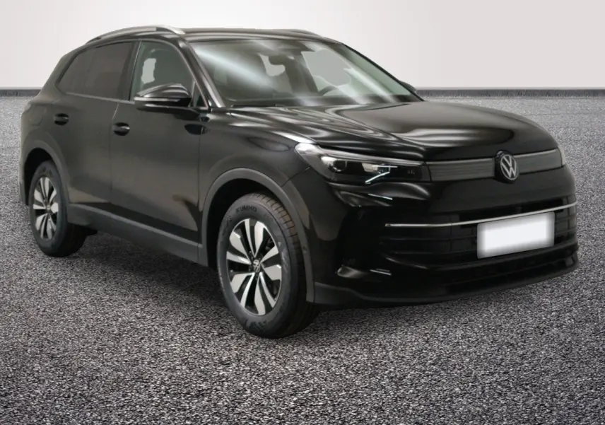Volkswagen Tiguan noir vu 3/4 avant droit, avec jantes distinctives et calandre épurée.