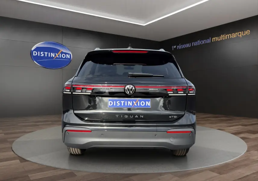 Vue arrière d'un Volkswagen Tiguan noir avec feux arrière LED reliés par une barre lumineuse rouge.