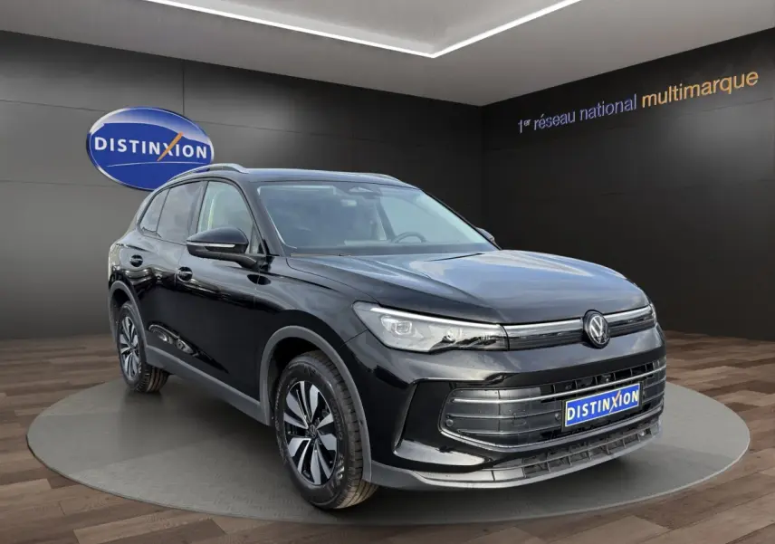Volkswagen Tiguan noir en 3/4 avant droit, avec calandre chromée et jantes alliage distinctives.