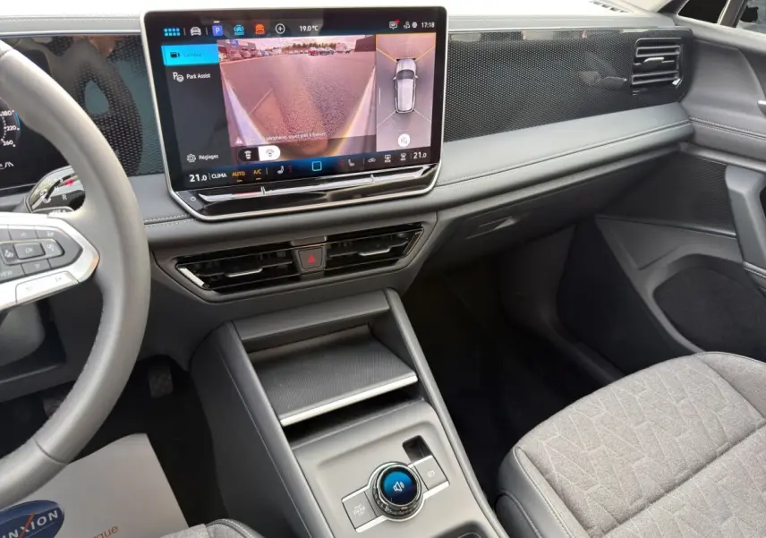 Vue intérieure avant droite du Volkswagen Tiguan 2026, tableau de bord noir avec écran tactile affichant caméra 360 et console centrale moderne.