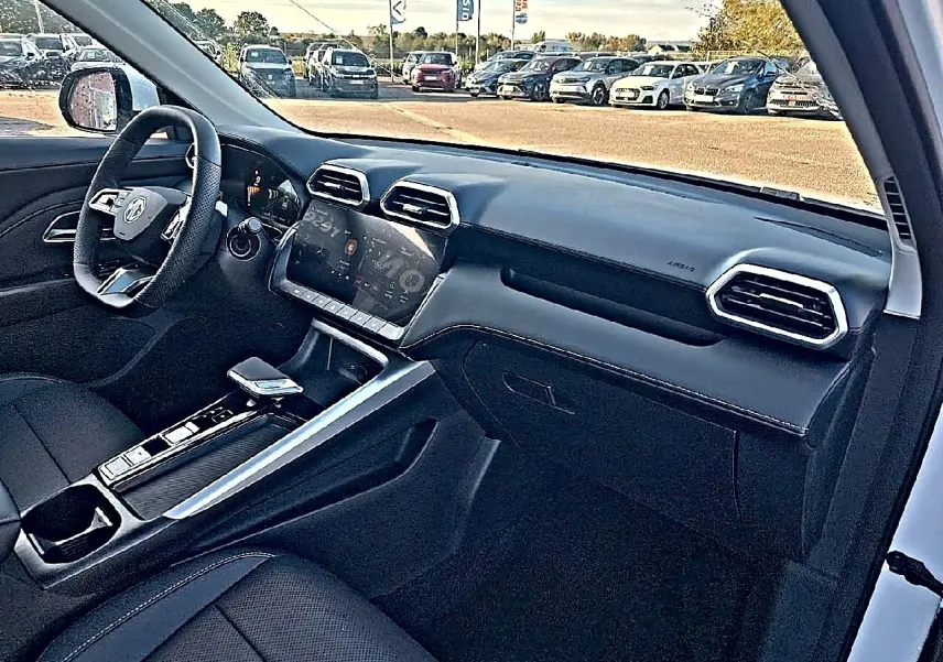 Intérieur noir du MG Motor ZS 1.5 hybrid 197 luxury vu côté passager, avec tableau de bord moderne et écran tactile.
