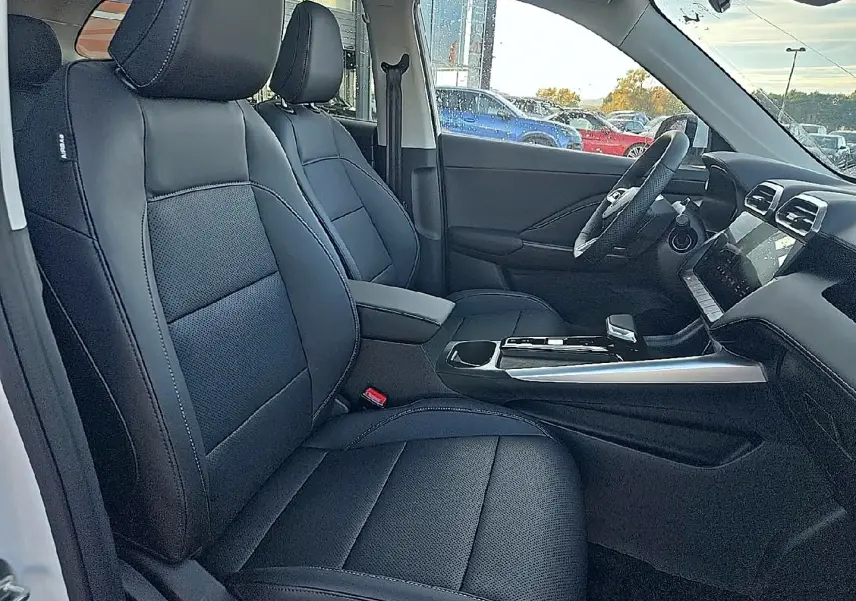 Vue intérieure côté conducteur du MG Motor ZS 1.5 hybrid 197 luxury avec sièges noir similicuir et console centrale moderne.