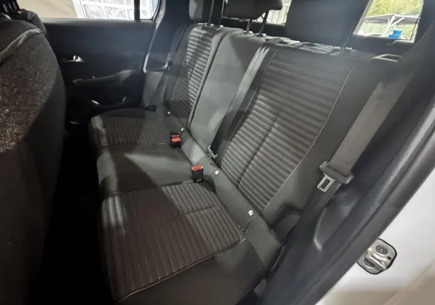 Vue intérieure arrière droite de la banquette noire de la Peugeot 208 PureTech 75 S&S Active blanche 2024.