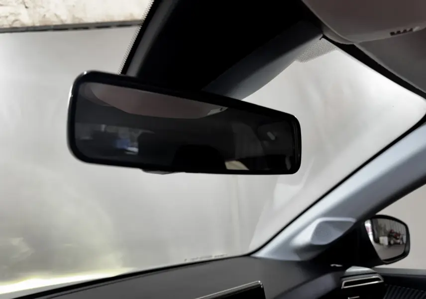 Intérieur de la Peugeot 208 PureTech 75 S&S Active 2024, vue côté conducteur avec rétroviseur et tableau de bord noir.