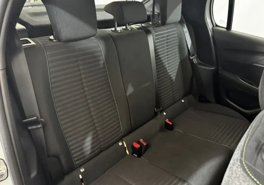 Vue intérieure arrière de la banquette noire de la Peugeot 208 PureTech 75 S&S Active, avec ceintures et appuie-têtes.