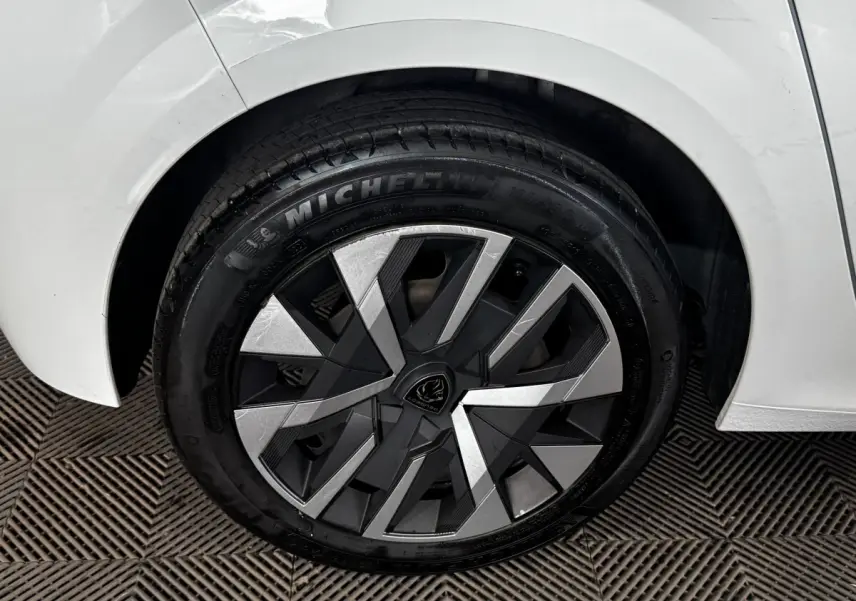Gros plan sur la roue arrière droite blanche d’une Peugeot 208 PureTech 75 S&S Active avec jante moderne bicolore.