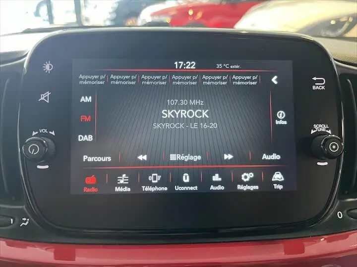 Écran tactile central de la Fiat 500 rouge 2023 affichant la radio Skyrock en intérieur véhicule