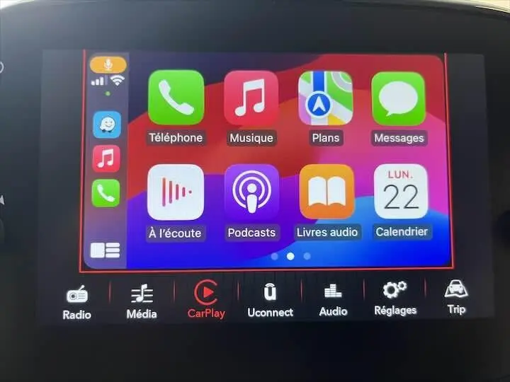 Écran tactile du système multimédia de la Fiat 500 rouge, affichant l'interface Apple CarPlay colorée.