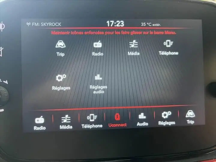Écran tactile du système multimédia de la Fiat 500 rouge, affichant les options radio, téléphone et réglages.