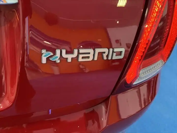 Gros plan sur l'arrière droit rouge brillant d'une FIAT 500 hybride avec le badge "HYBRID" visible près du feu arrière.