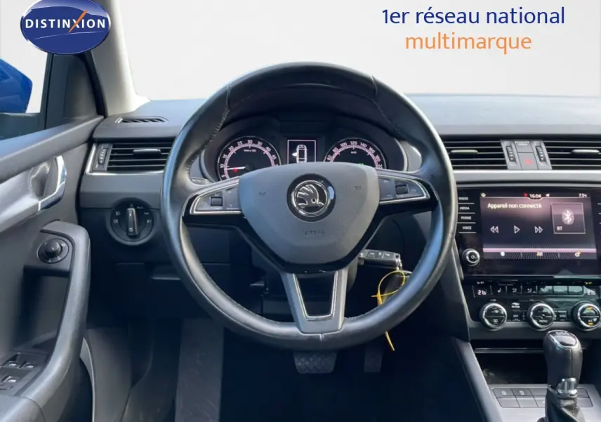 Vue frontale du volant et du tableau de bord noir de la Skoda Octavia Combi 2019 avec écran tactile et commandes au volant.