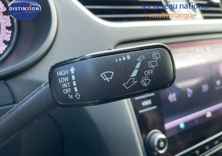 Gros plan sur la commande des essuie-glaces à gauche du volant dans l’habitacle gris d’une Skoda Octavia Combi bleu racing metal.