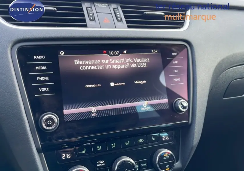 Vue rapprochée de la console centrale de la Skoda Octavia Combi 2019, écran tactile avec interface SmartLink et commandes de climatisation.