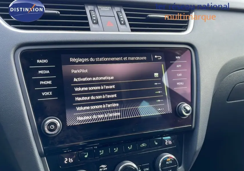 Vue rapprochée de l’écran tactile central et de la console de la Skoda Octavia Combi 2019 bleu racing metal, affichant les réglages ParkPilot.