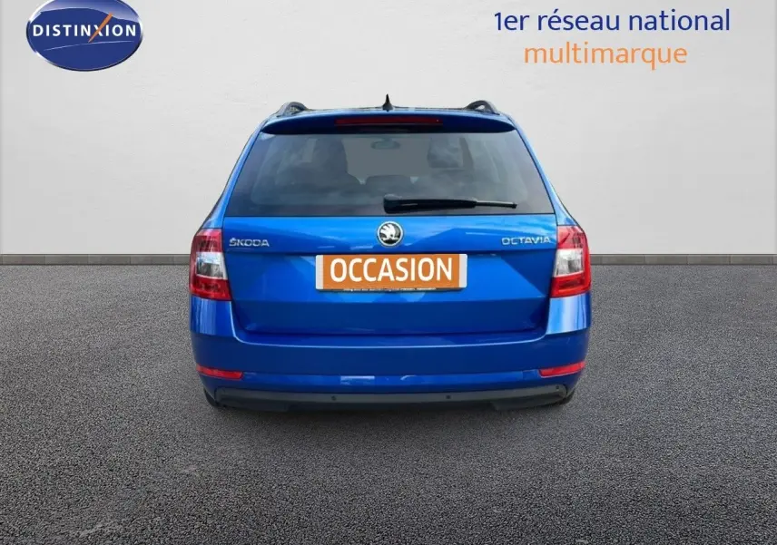 Vue arrière d'une Skoda Octavia Combi bleu racing metal avec plaque "OCCASION" sur fond neutre.
