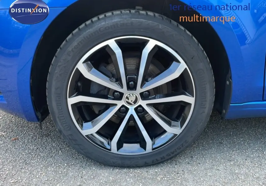 Gros plan sur la roue avant gauche de la Skoda Octavia Combi bleu racing métal avec jante alliage bicolore.