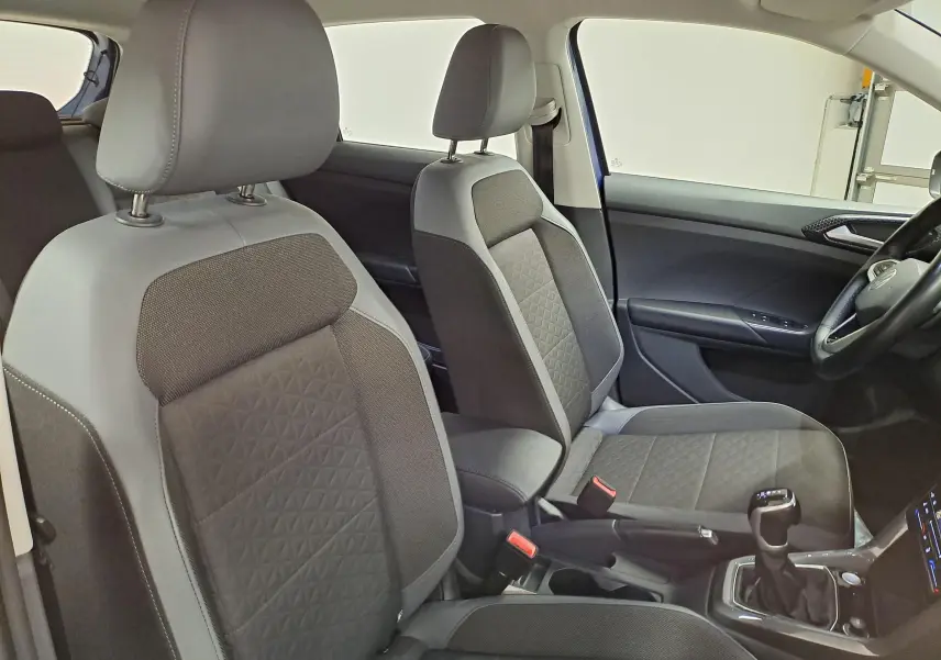 Vue intérieure des sièges avant gris et noir du Volkswagen T-Cross 2022, côté droit avec console centrale et levier de vitesse.