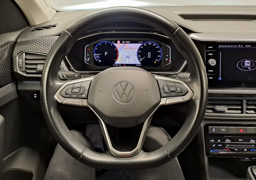 Vue centrée sur le volant et le tableau de bord numérique du Volkswagen T-Cross 2022, intérieur noir moderne.