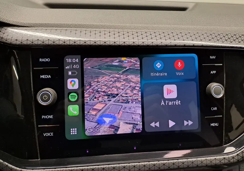 Vue rapprochée de l'écran tactile central du Volkswagen T-Cross 2022 avec navigation et commandes vocales affichées.