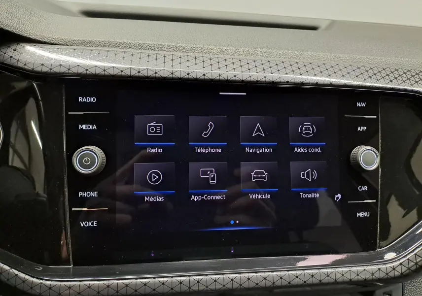 Vue rapprochée de l'écran tactile central du Volkswagen T-Cross 2022, affichant les options radio, navigation et aides à la conduite.