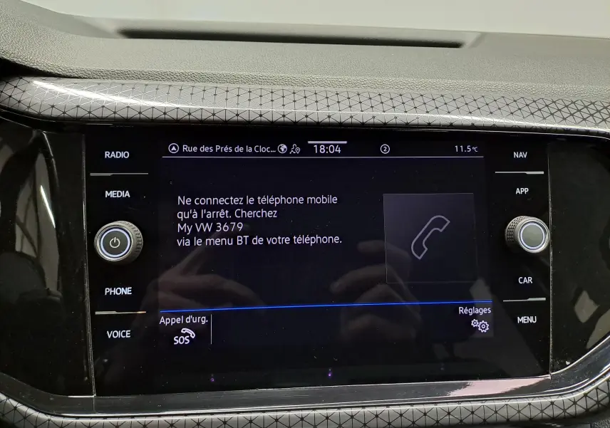 Écran tactile central du Volkswagen T-Cross 2022 affichant un message de connexion Bluetooth, entouré de boutons fonctionnels.