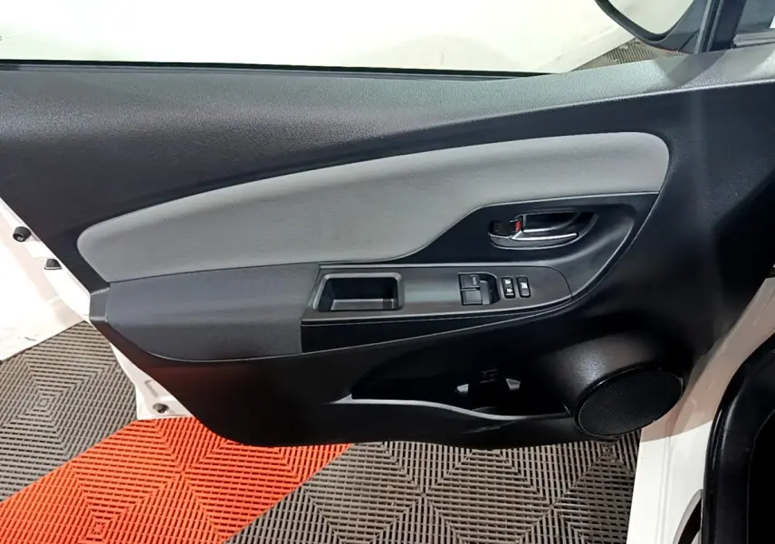 Intérieur côté gauche de la porte avant blanche de la Toyota Yaris 2019, avec commandes électriques et haut-parleur intégré.