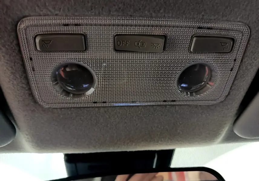 Plafonnier intérieur avec commandes d'éclairage et spots dans une Toyota Yaris hybride blanche de 2019.