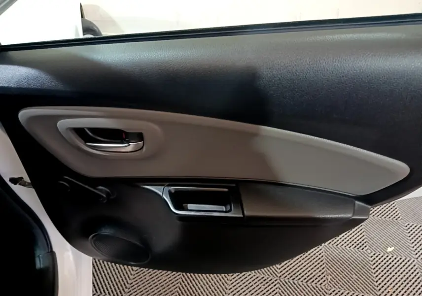 Vue rapprochée de la porte arrière gauche intérieure noire et grise d'une Toyota Yaris blanche 2019.